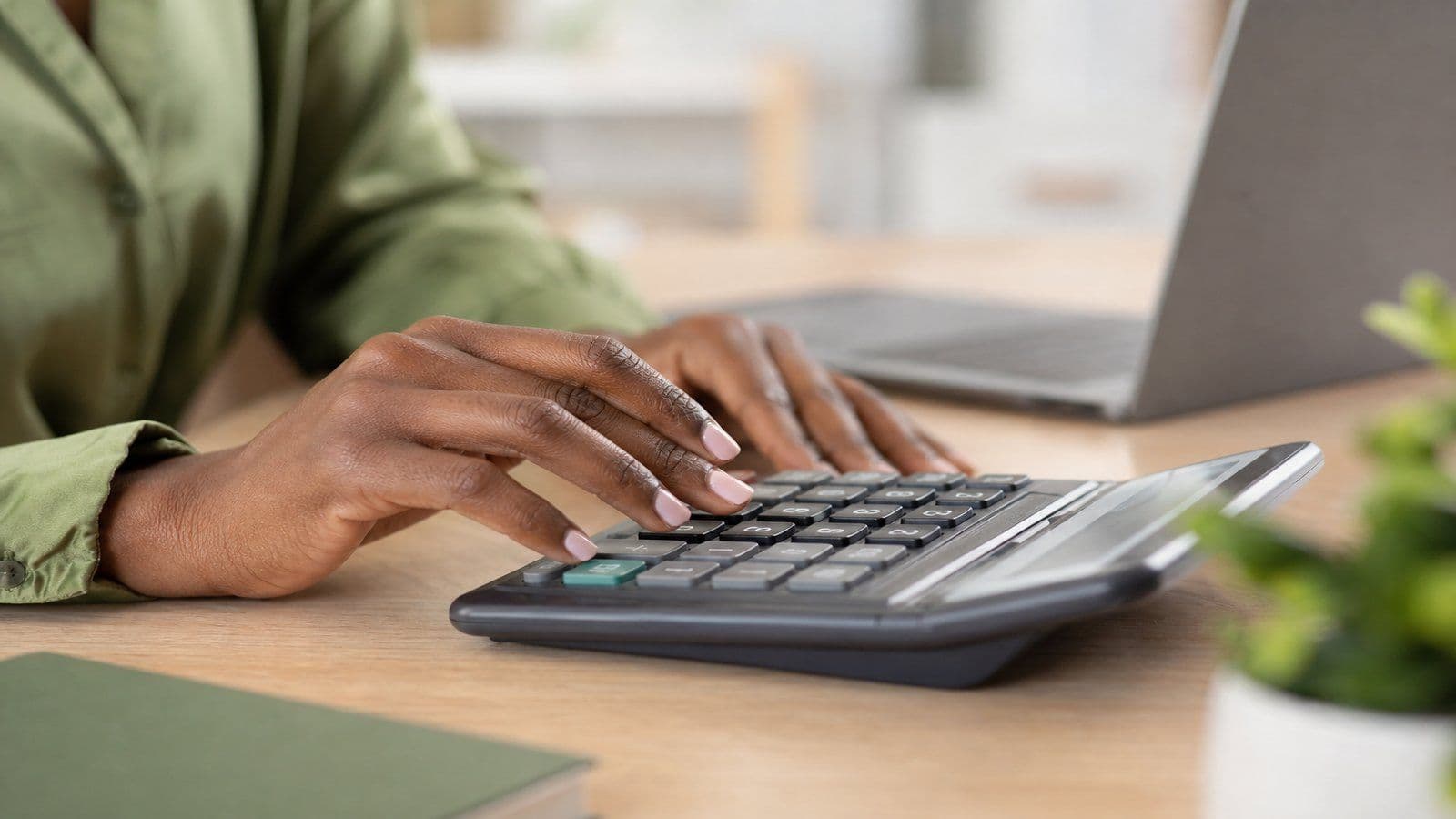 A bookkeeper works through the month's figures by hand